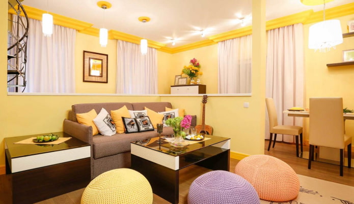 светло-желтая гостиная с разноцветными подушками и вязаными пуфиками