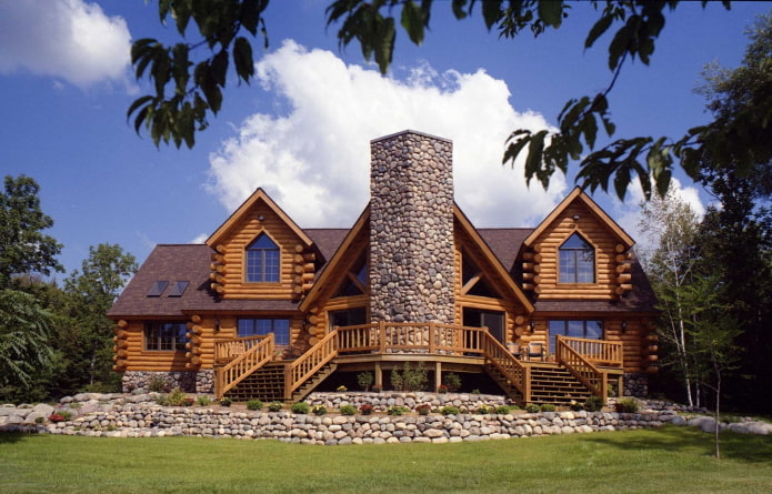дом из оцилиндрованного бревна и камня с коричневой крышей