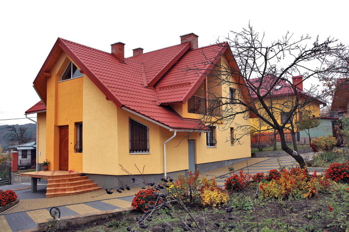 оранжево-желтый коттедж с красной крышей